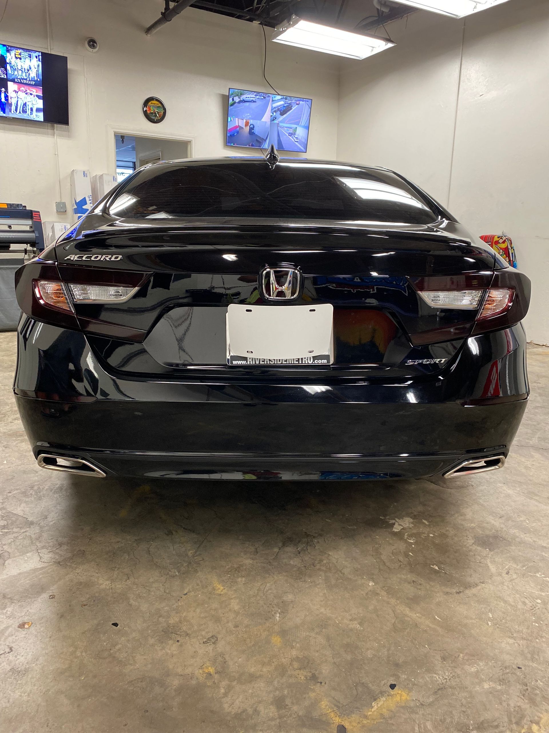 Black Toyota sedan parked in a garage, viewed from the rear.