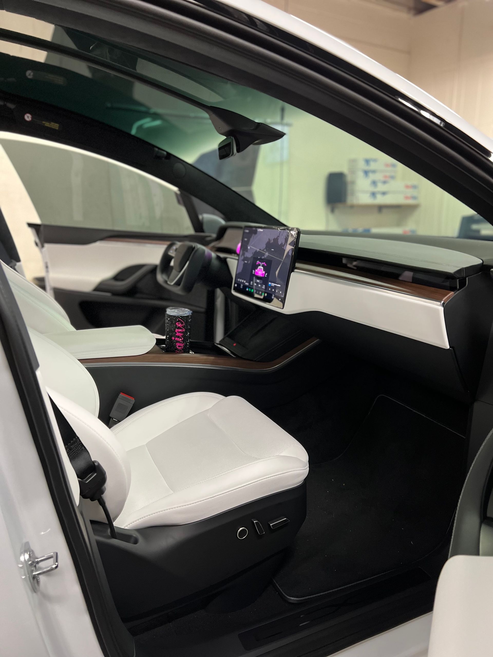 Modern car interior with white seats, black dashboard, and center touchscreen display