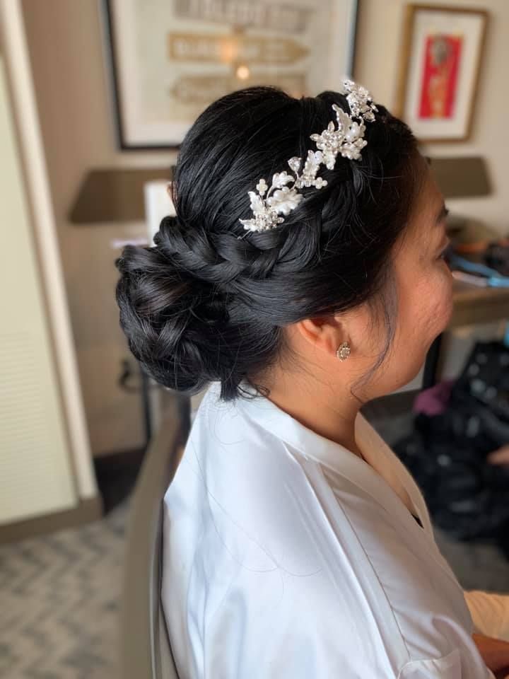 A woman is wearing a braided bun and a headpiece.