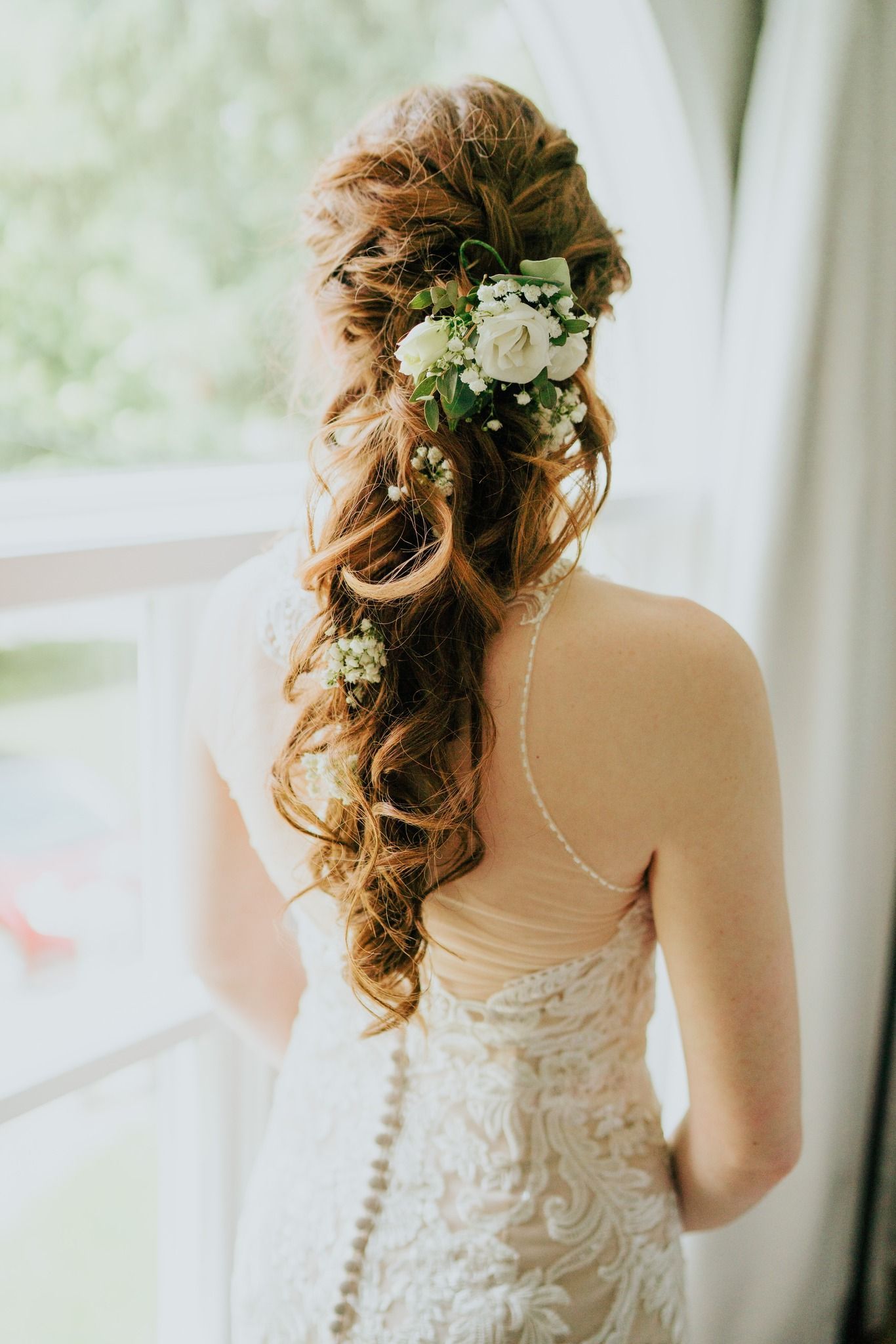 The bride is wearing a wedding dress and has flowers in her hair.