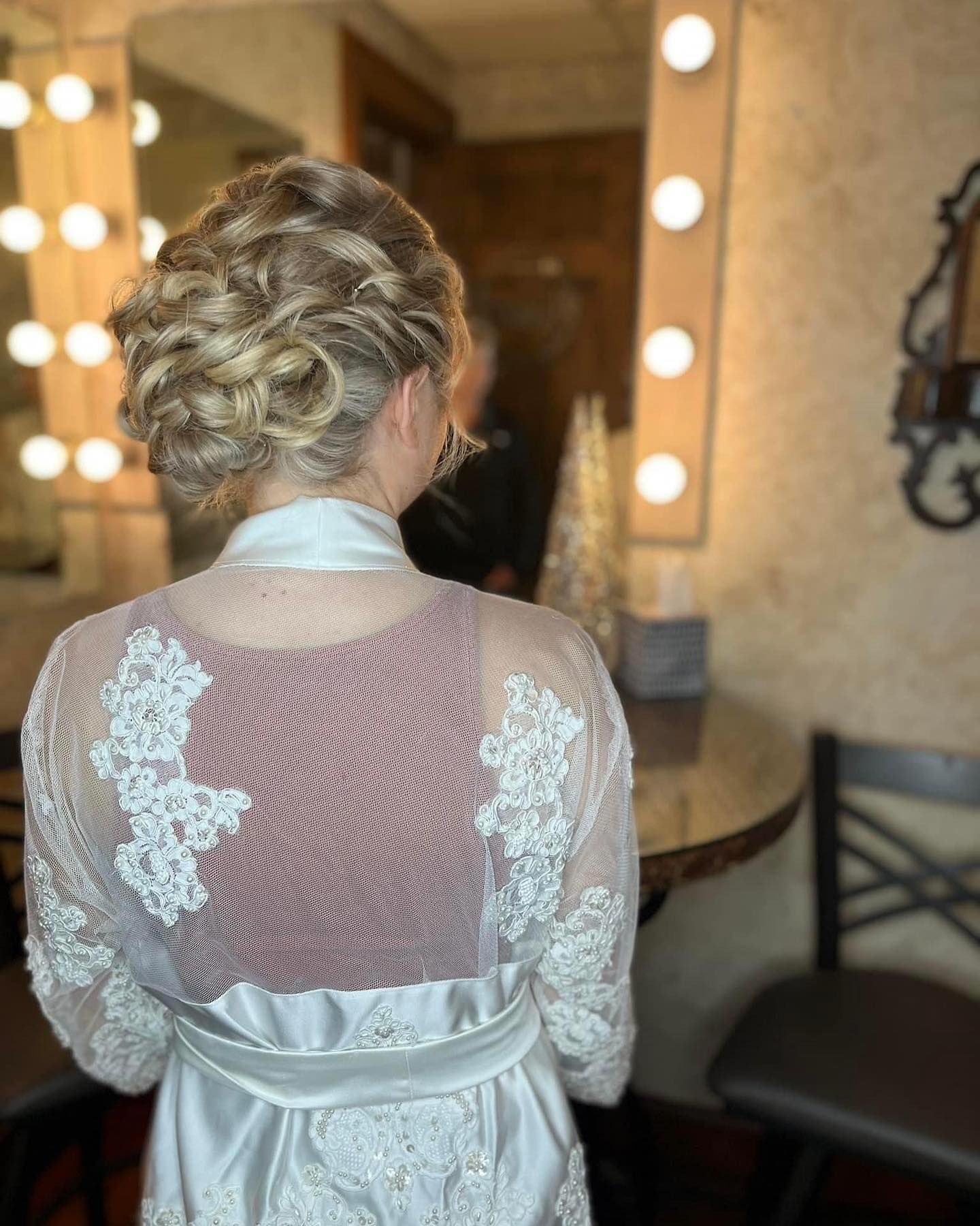 A woman in a white robe is standing in front of a mirror.