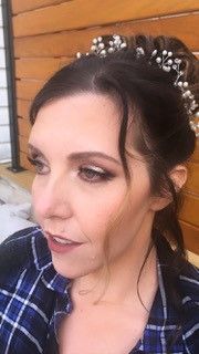 A close up of a woman wearing a tiara and a plaid shirt.