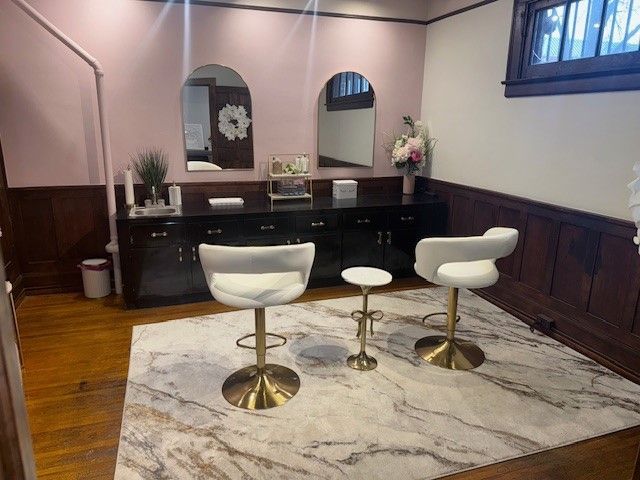 A room with two chairs and two mirrors on the wall