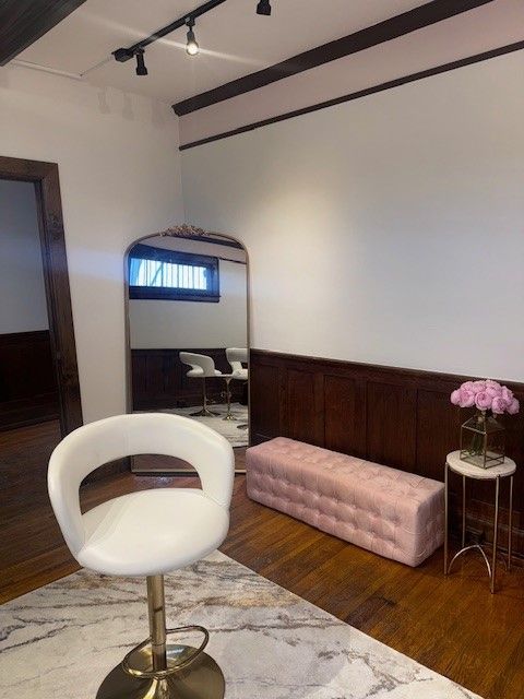 A room with a white chair and a mirror