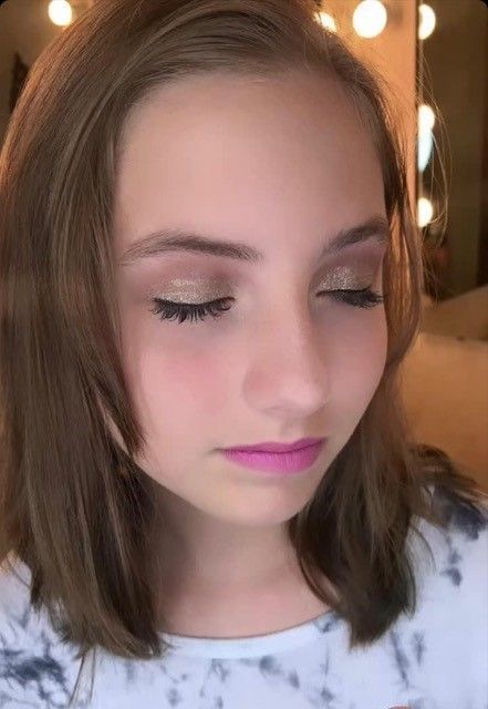 A close up of a young girl 's face with her eyes closed.