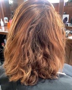 The back of a woman 's hair is shown in a salon.
