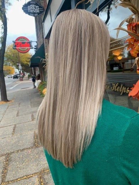A woman with long blonde hair wearing a green sweater