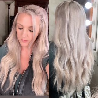 A woman with long blonde hair is standing in front of a mirror.