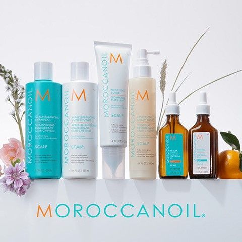 A group of Moroccan Oil products are sitting next to each other on a table.