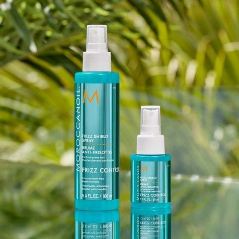 A bottle of Moroccan Oil frizz control is next to a smaller bottle.