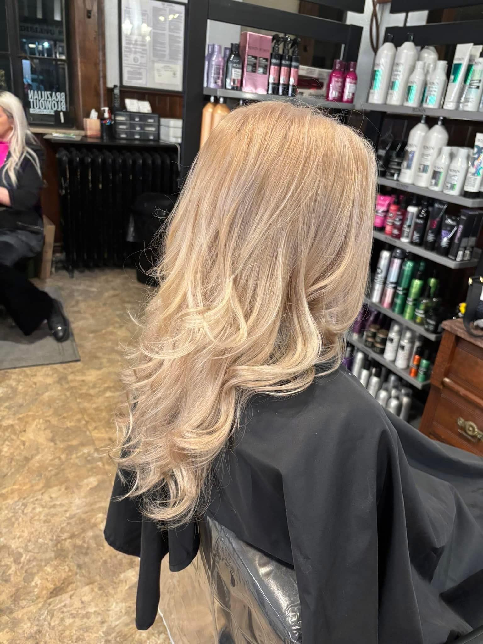 A woman is getting her hair cut in a salon
