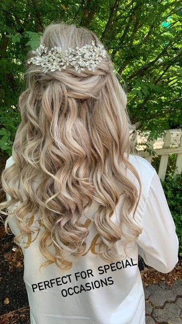 A woman with long blonde hair is wearing a white shirt that says