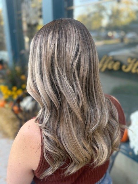 Woman with wavy light brown hair with highlights.