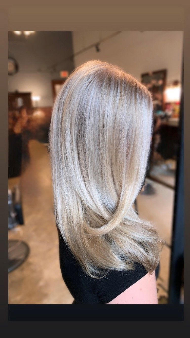 Woman with layered, blonde hair in a salon.