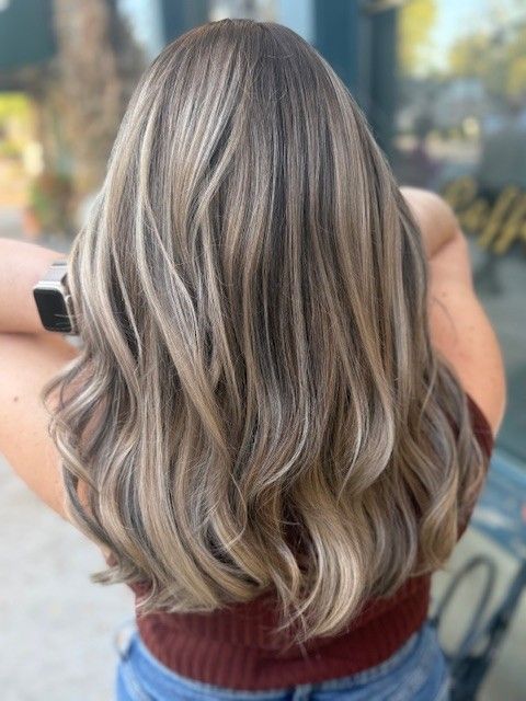 Woman with wavy, highlighted blonde and brown hair.