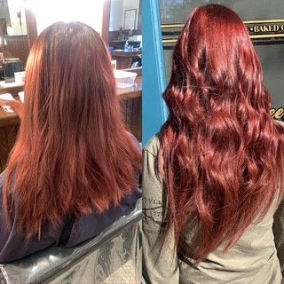 A woman with long red hair is sitting in a chair.