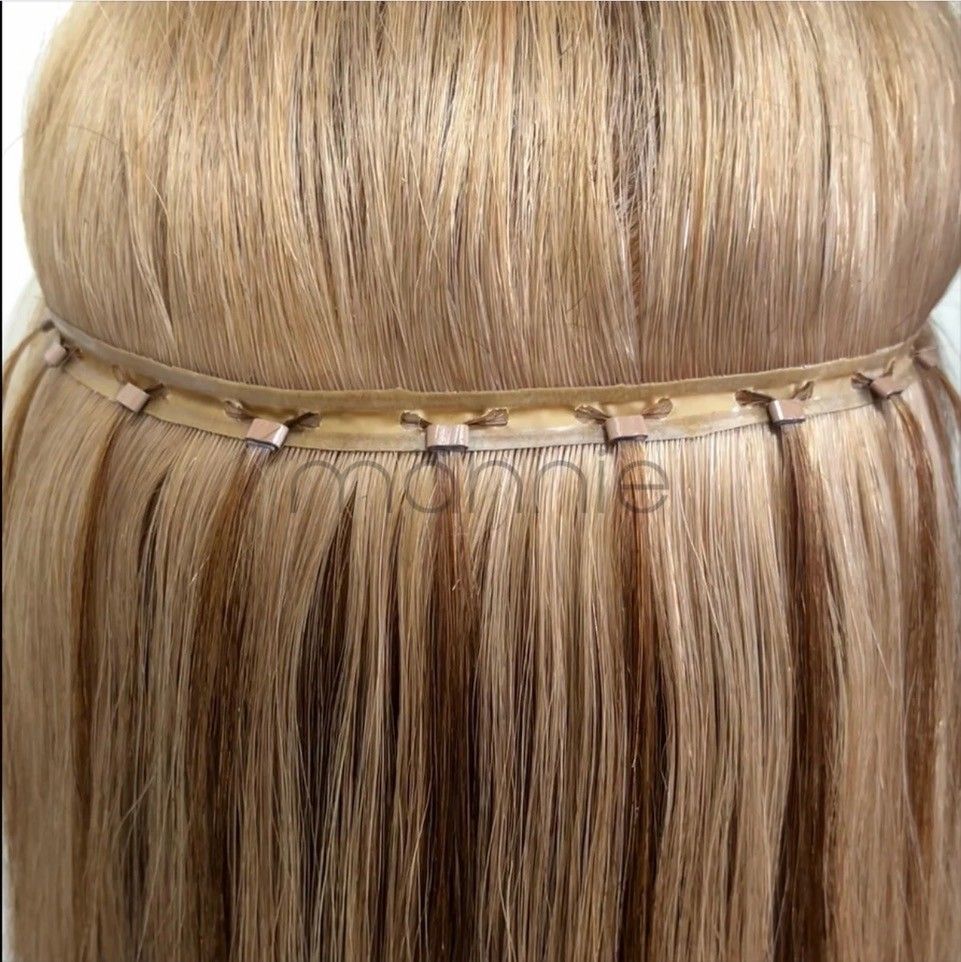 Blonde hair extensions clipped into a section of light blonde hair