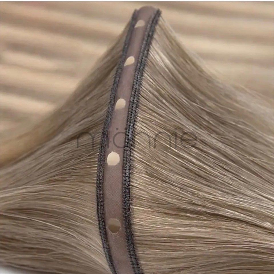 Close-up of blonde hair with a dark polka-dot clip securing a section.