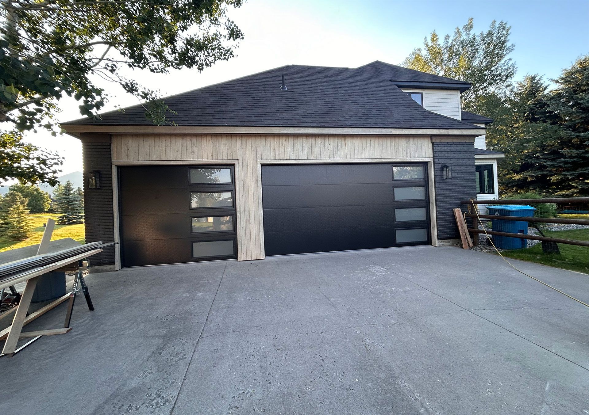 A large house with a black garage door is being built