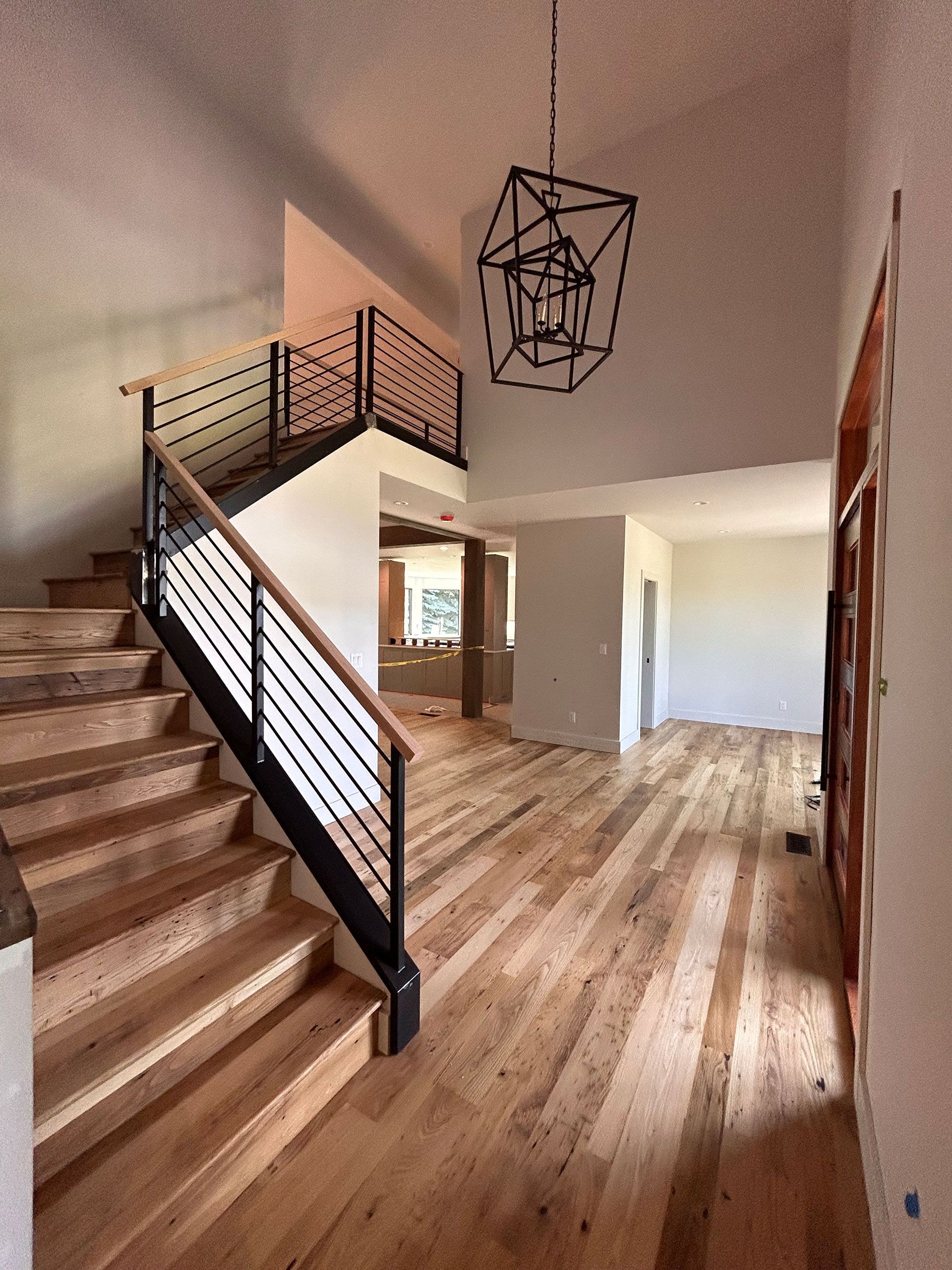 A wooden staircase with a black railing in a house