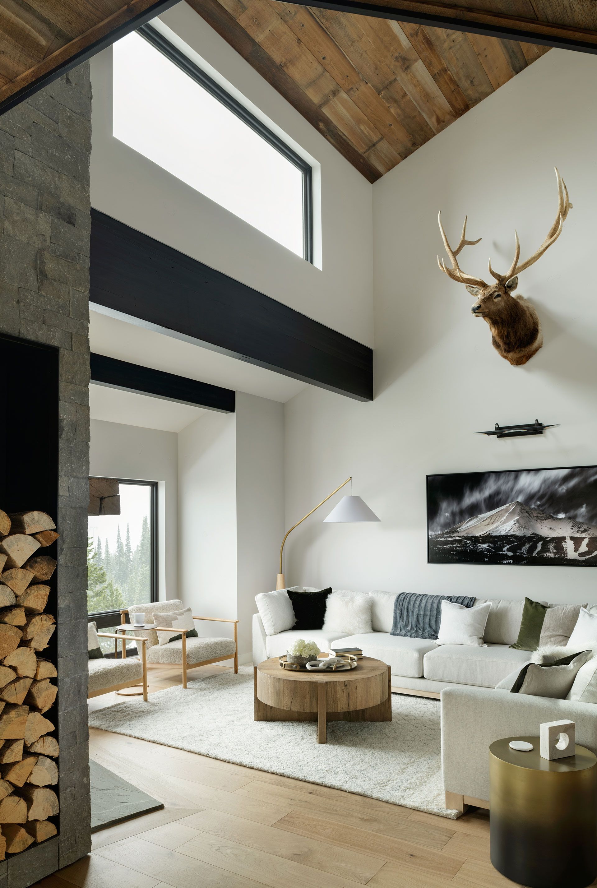 A living room with a deer head on the wall and a fireplace
