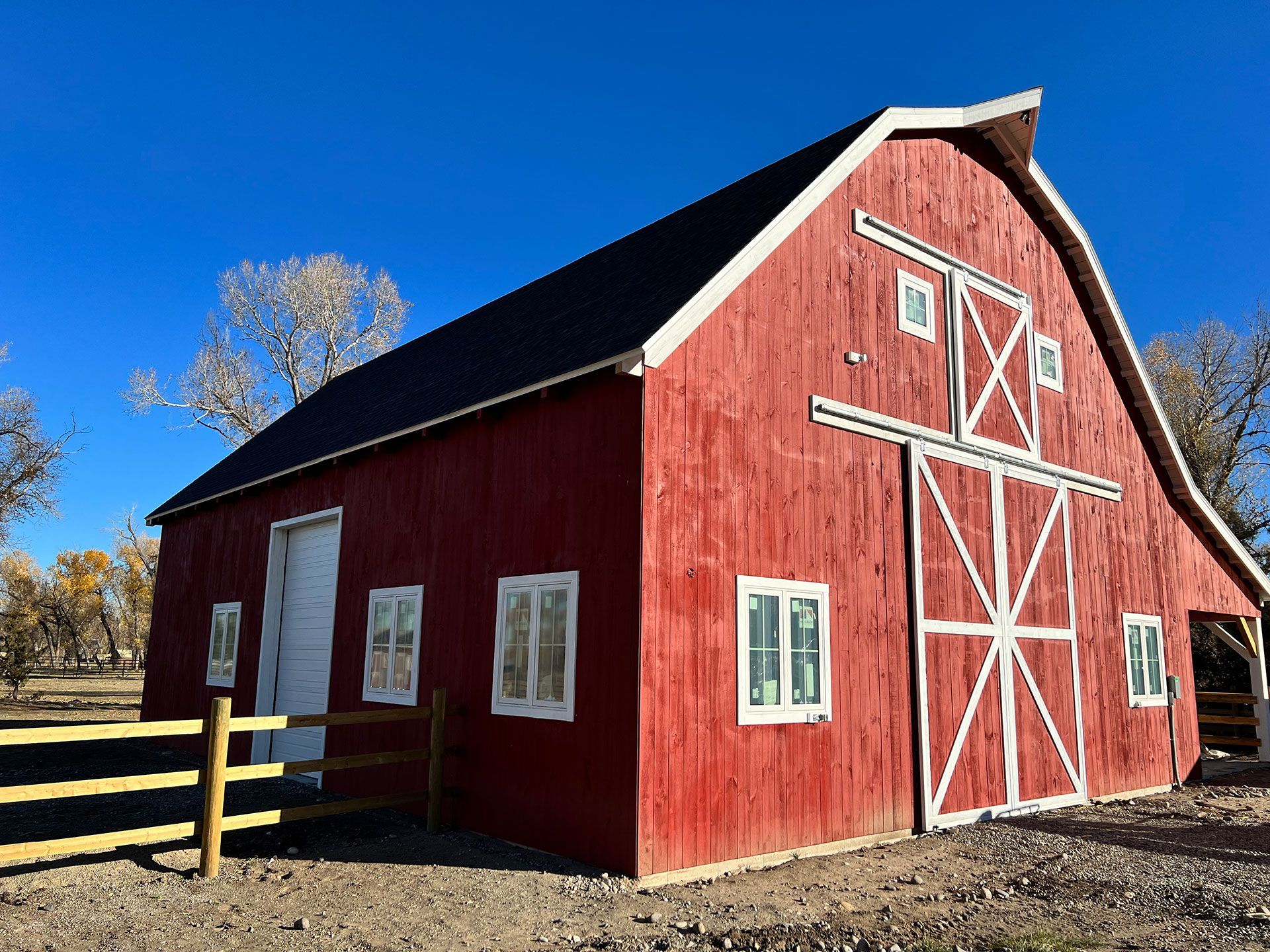 A large red barn with a wooden fence around it