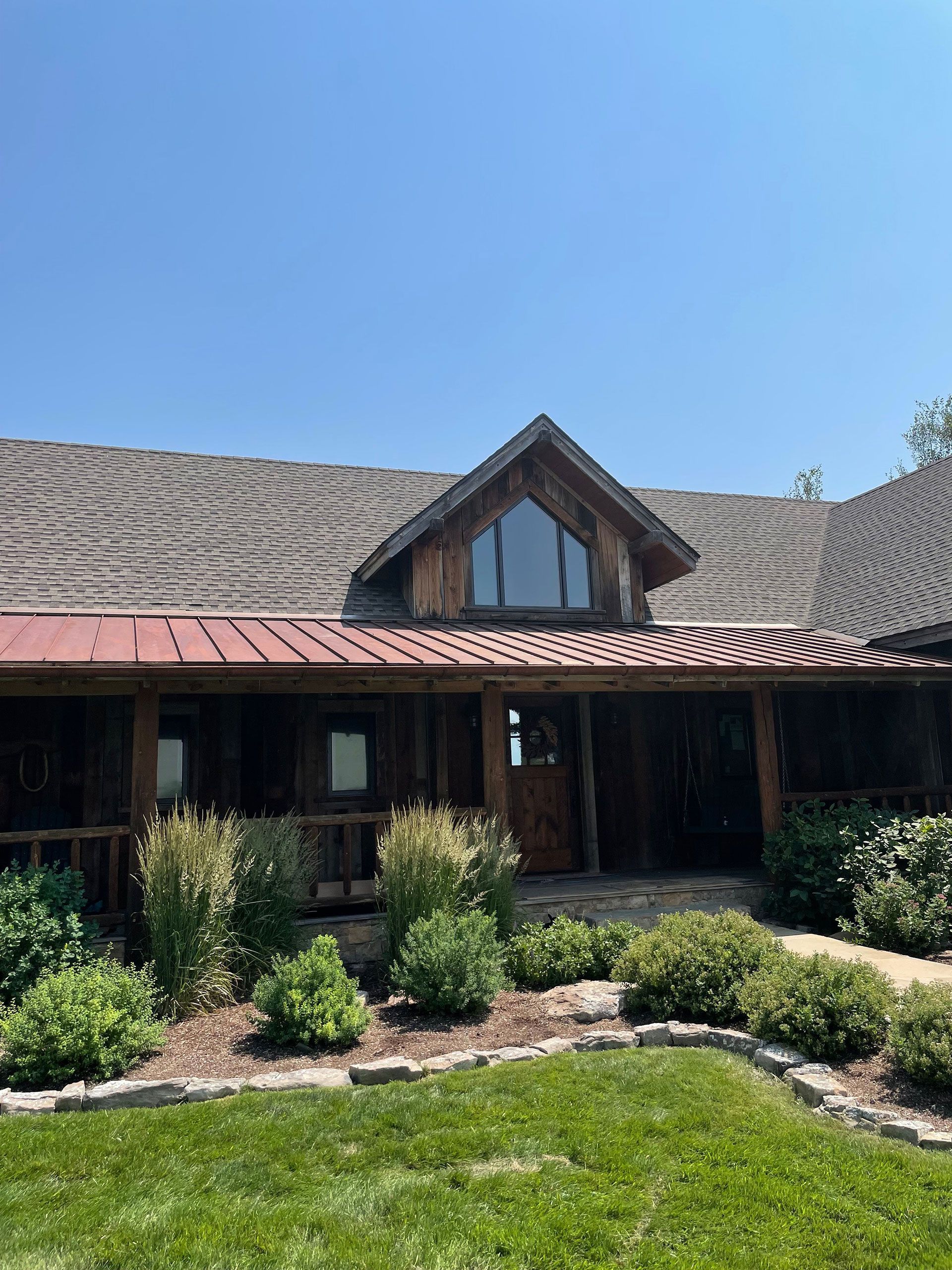 A large wooden house with a red roof and a large window