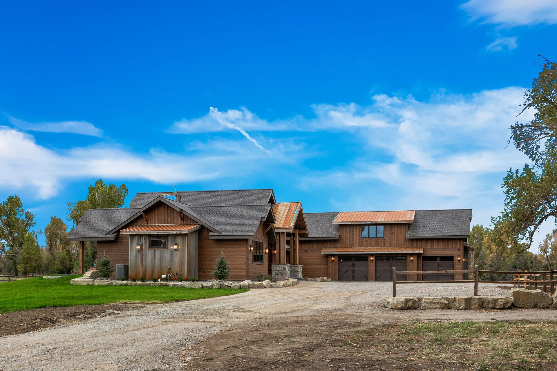 A large wooden house is sitting on top of a lush green field
