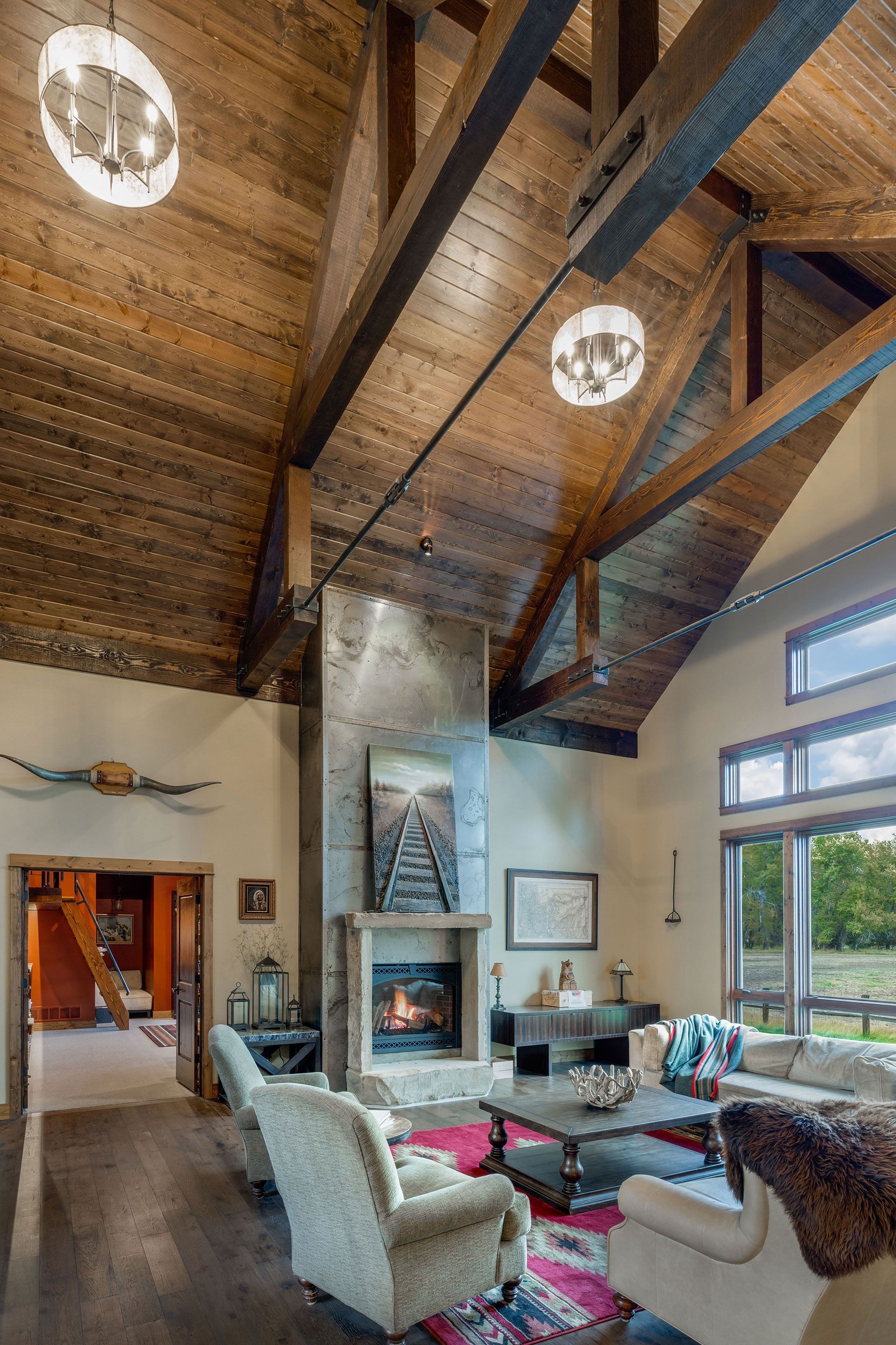 A living room with a vaulted ceiling and a fireplace
