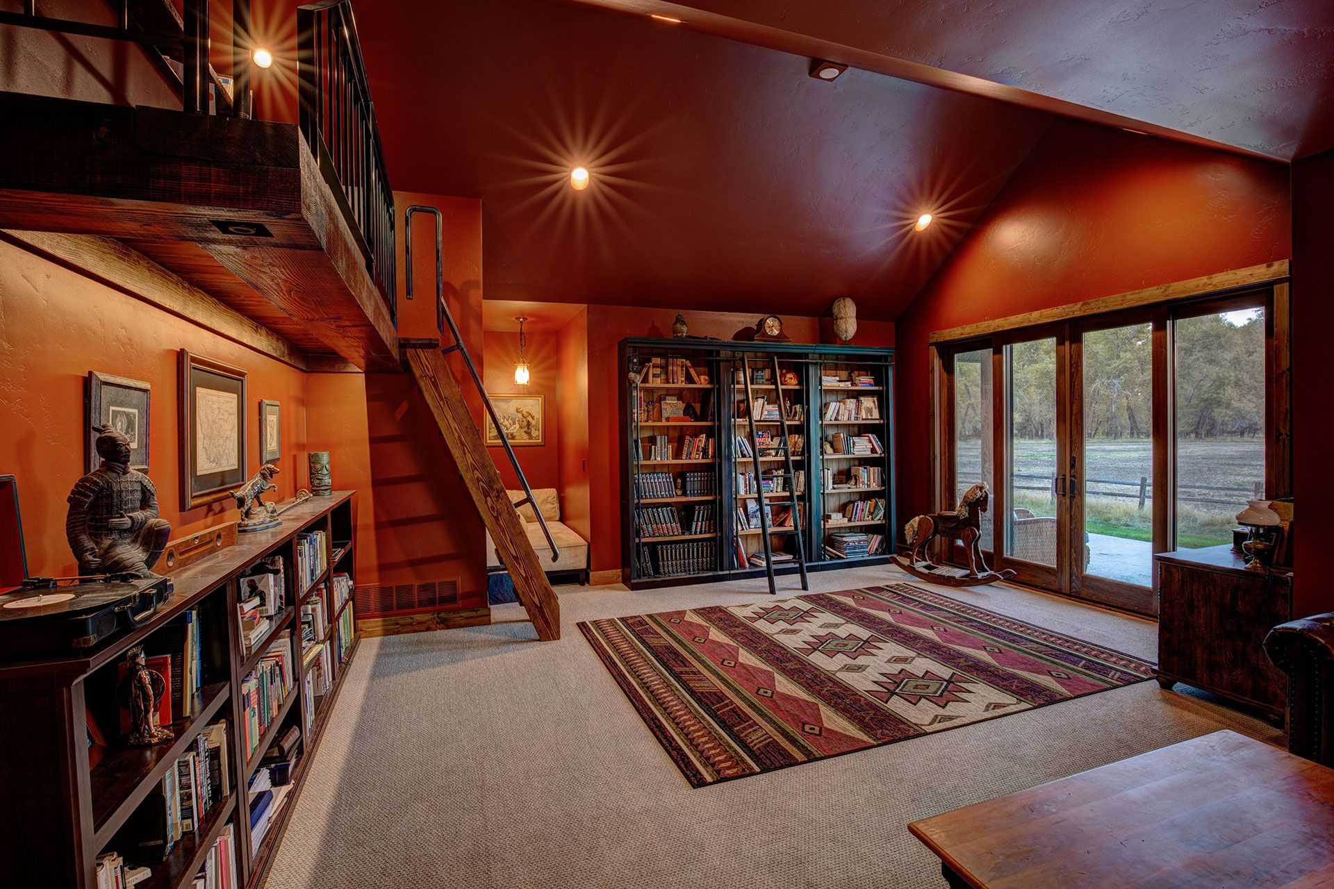 A living room with lots of bookshelves and a rug