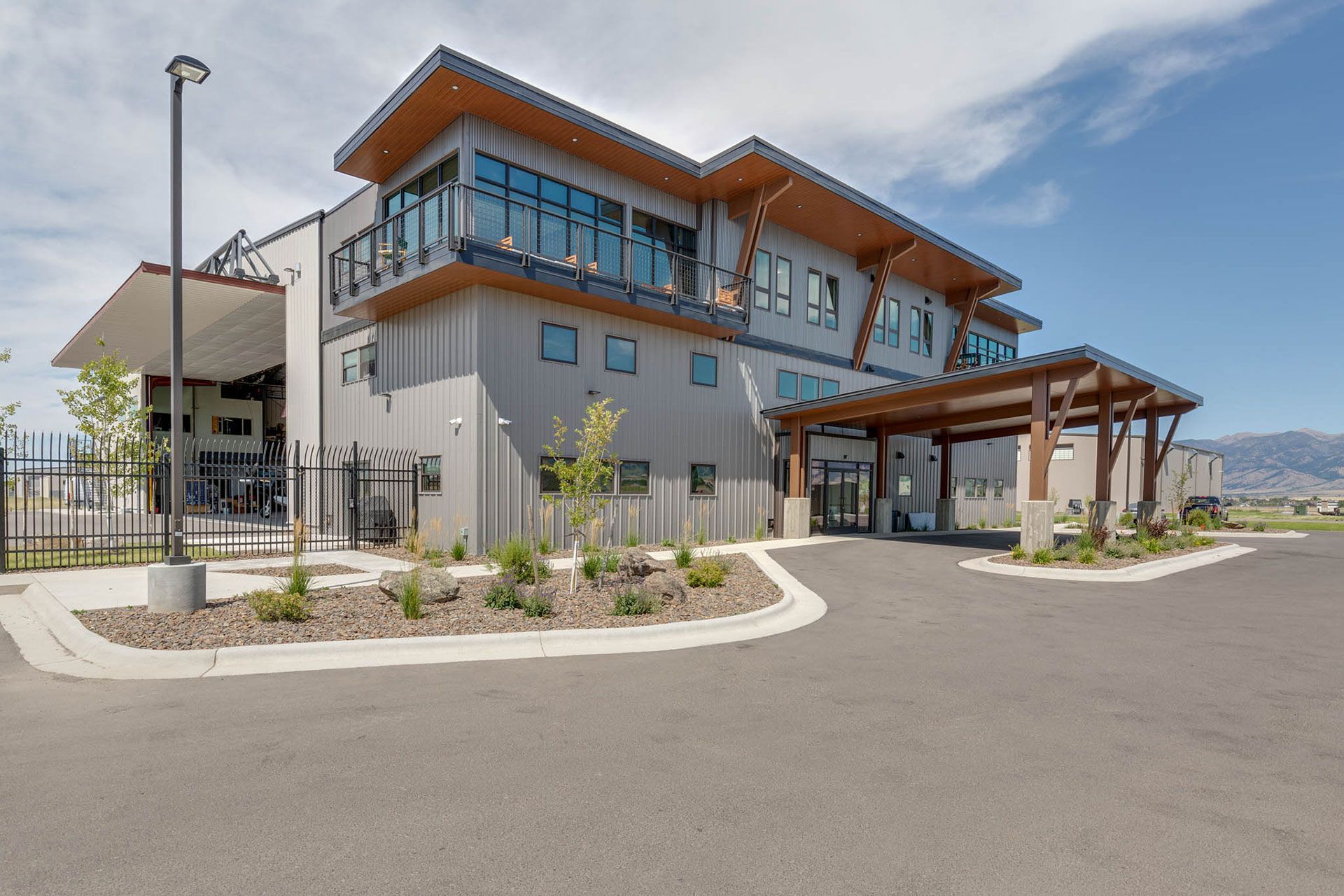 A large building with a lot of windows and a driveway in front of it
