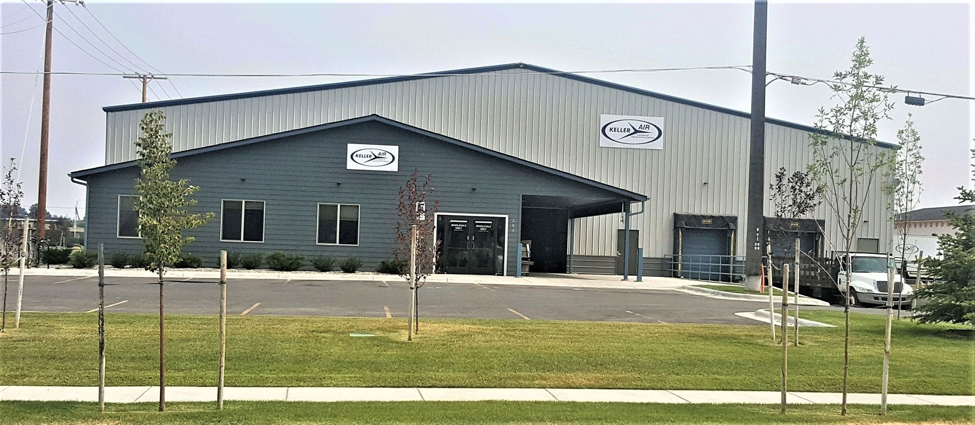 A large building with a lot of windows is sitting on top of a lush green field