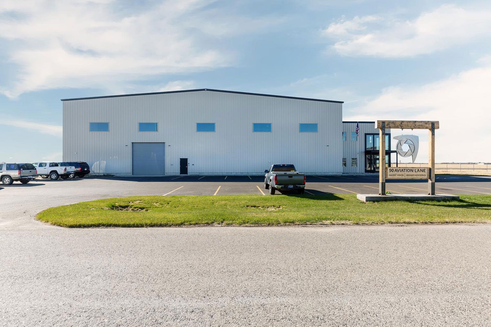 A large white building with cars parked in front of it