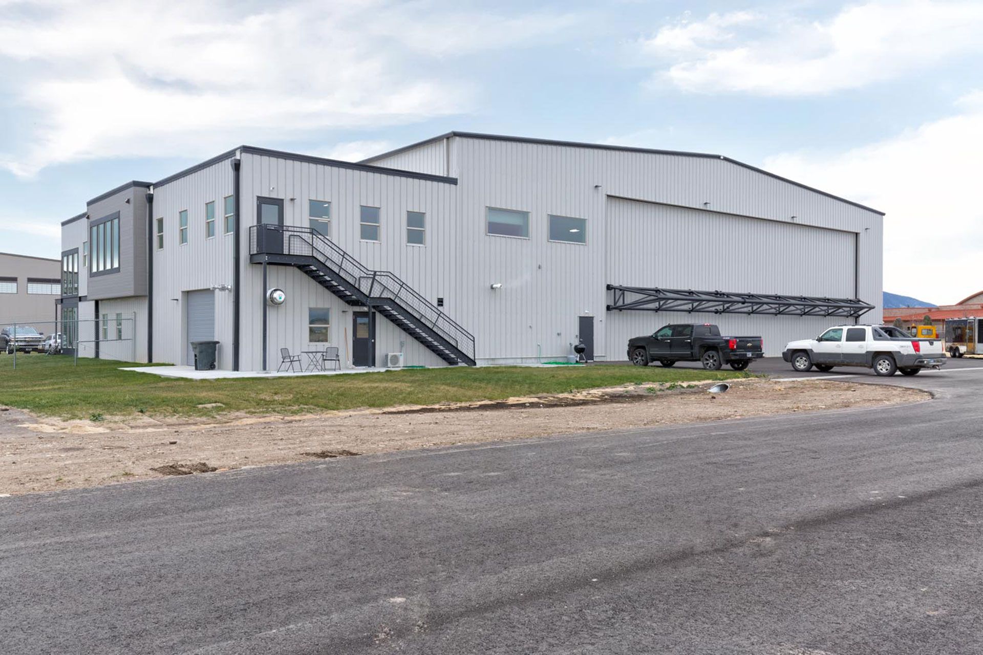 Two trucks are parked in front of a large building