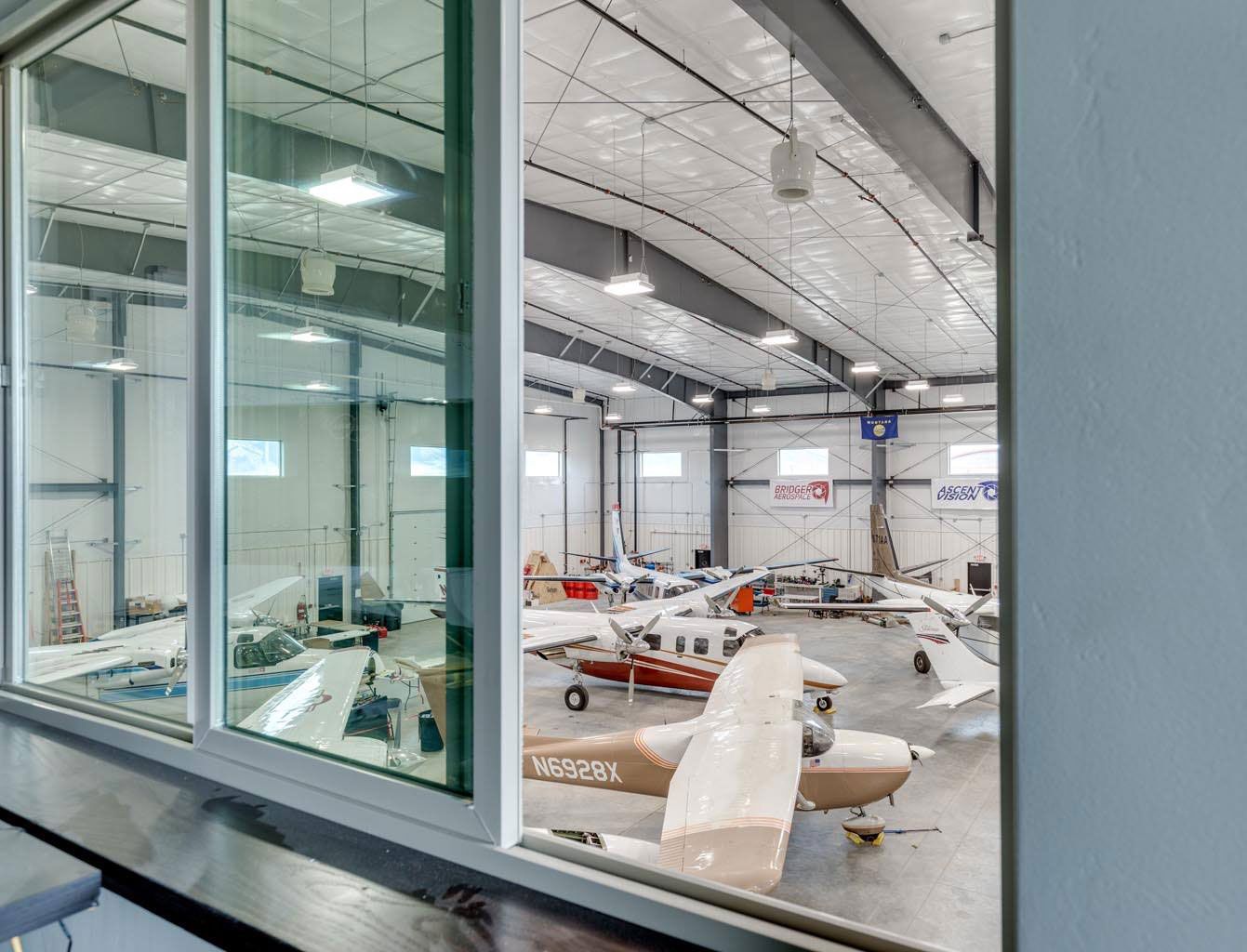 A view of planes in a hangar through a window