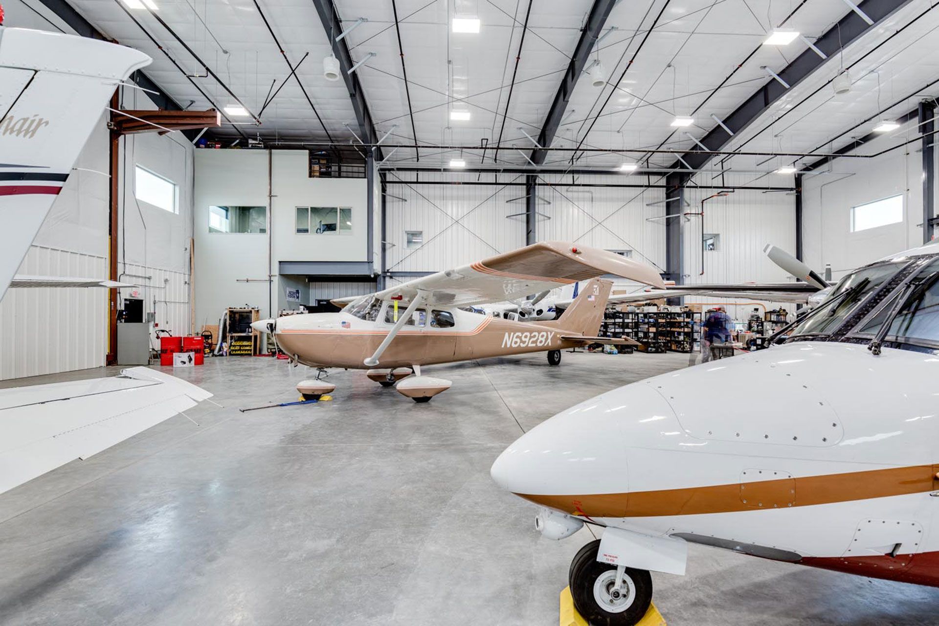 Two small planes are parked in a hangar