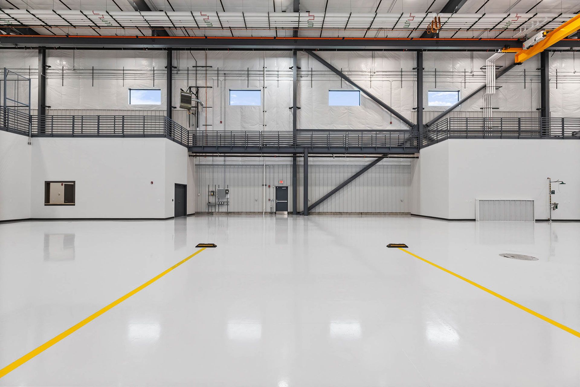 A large empty warehouse with a yellow line on the floor