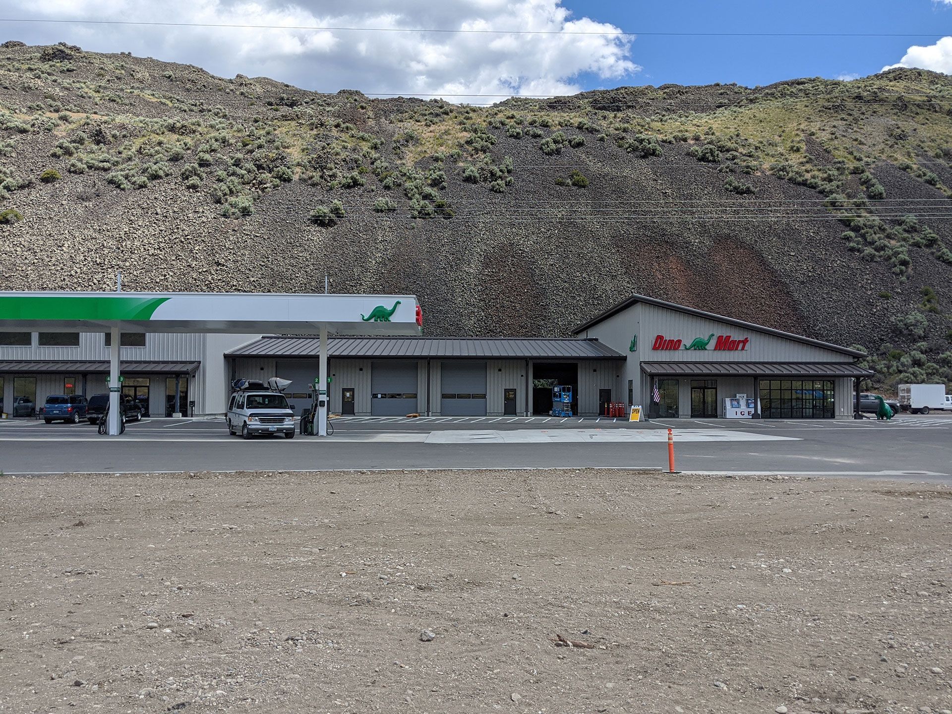 A gas station in the desert with mountains in the background