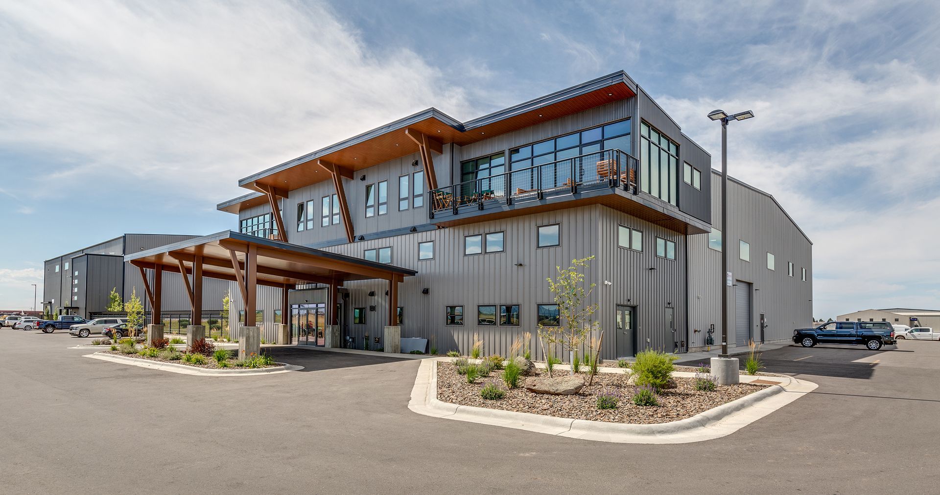 A large building with a lot of windows and a lot of cars parked in front of it.