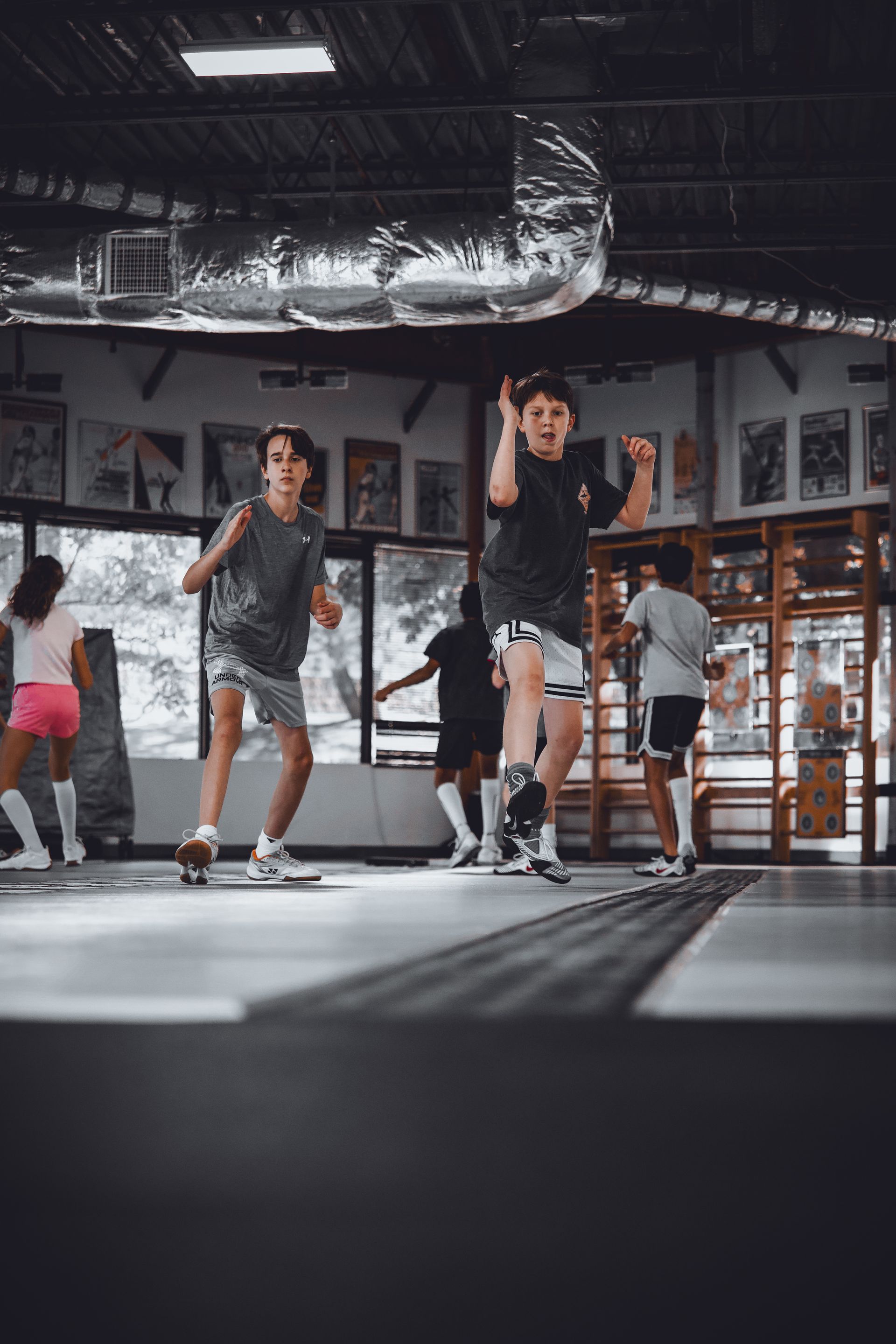 A group of young people are skateboarding in a gym.