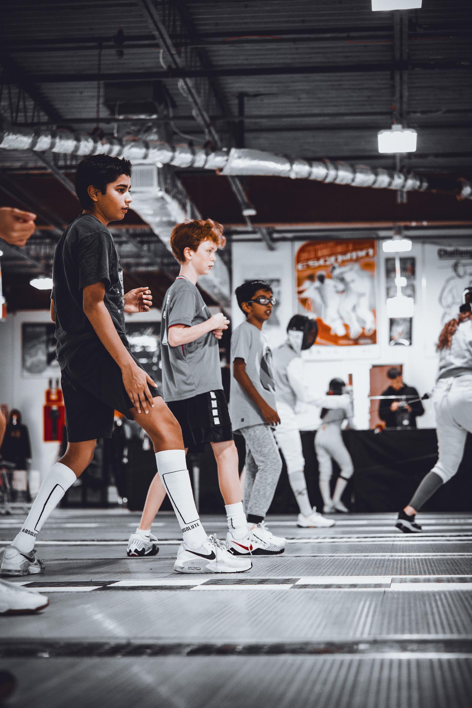 A group of young boys are walking in a gym.