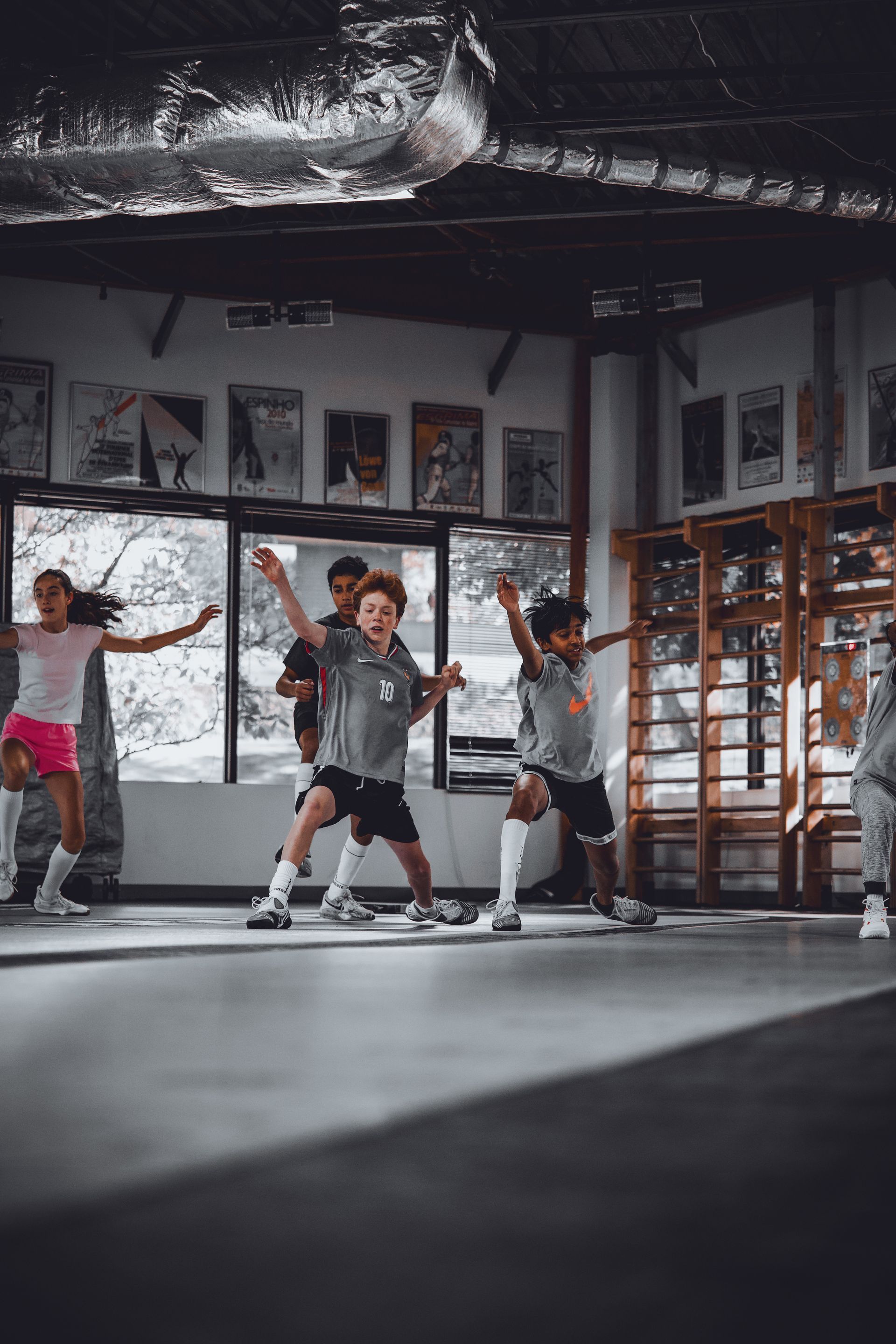 A group of children are dancing in a gym.