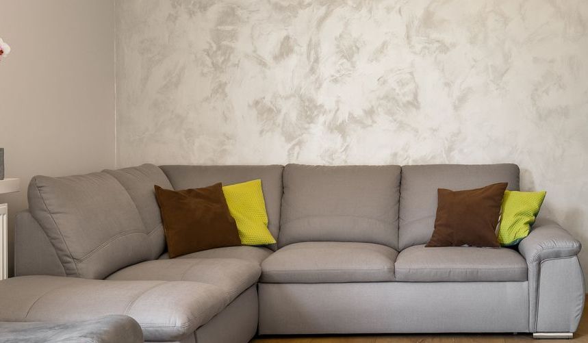 A living room with a large sectional couch and pillows.