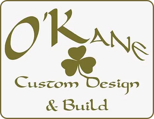 Logo for O'Kane Custom Design & Build with gold text on a white rectangle: Name, shamrock, "Custom Design & Build".