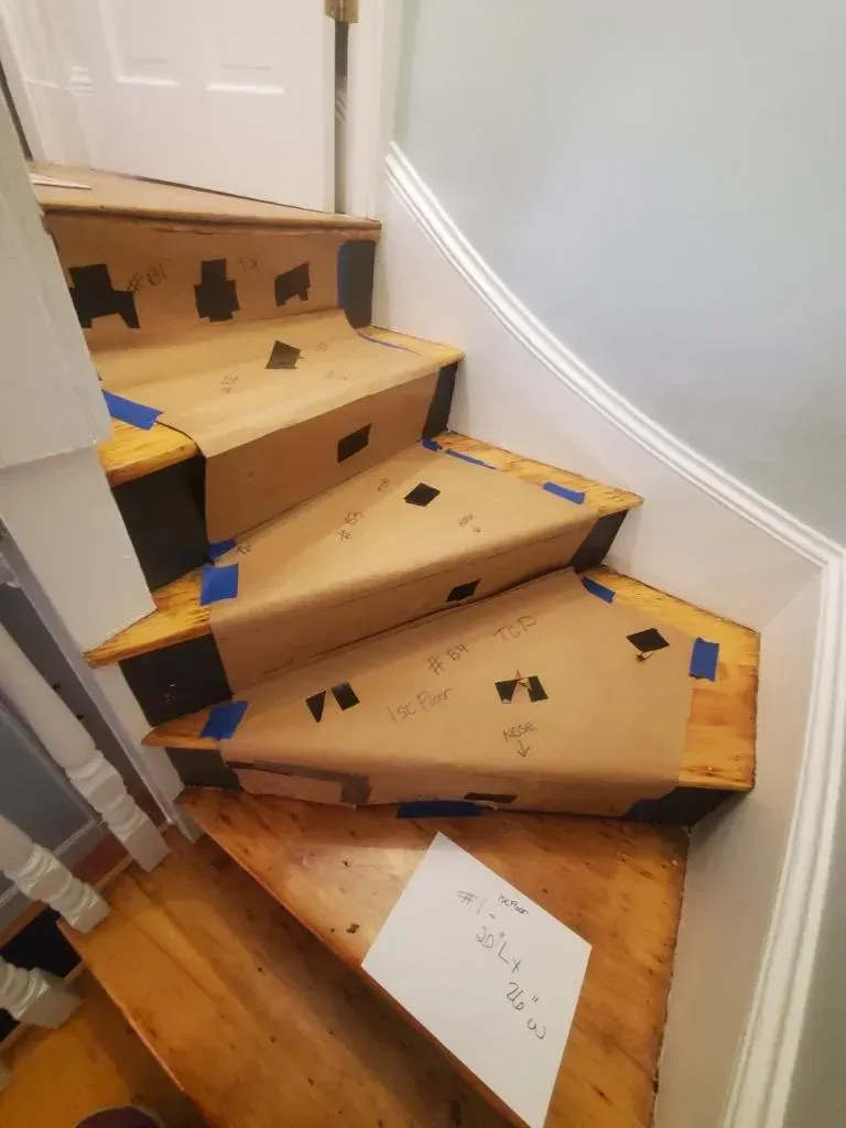 A wooden staircase with a piece of cardboard on the steps