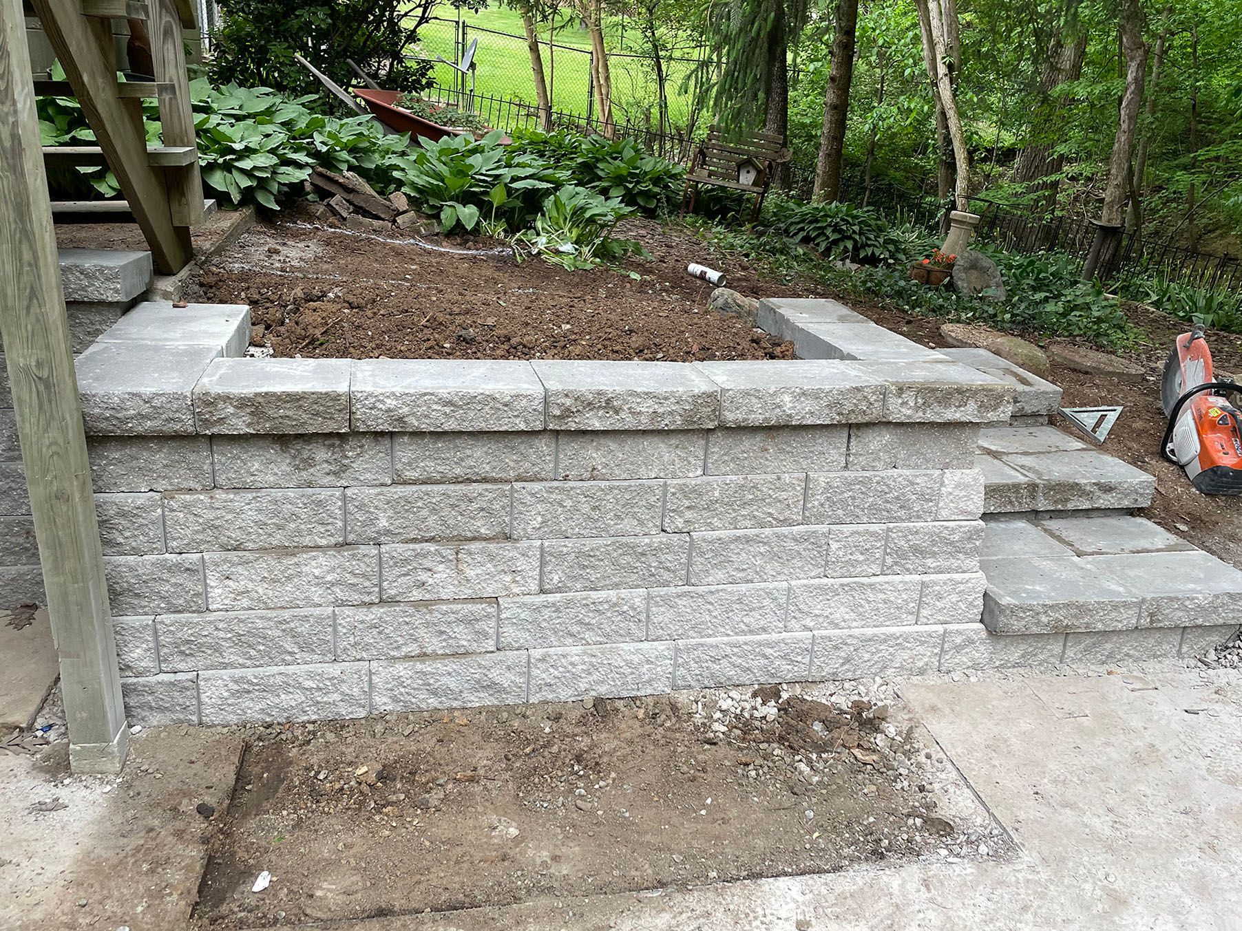 a brick wall is being built in a backyard