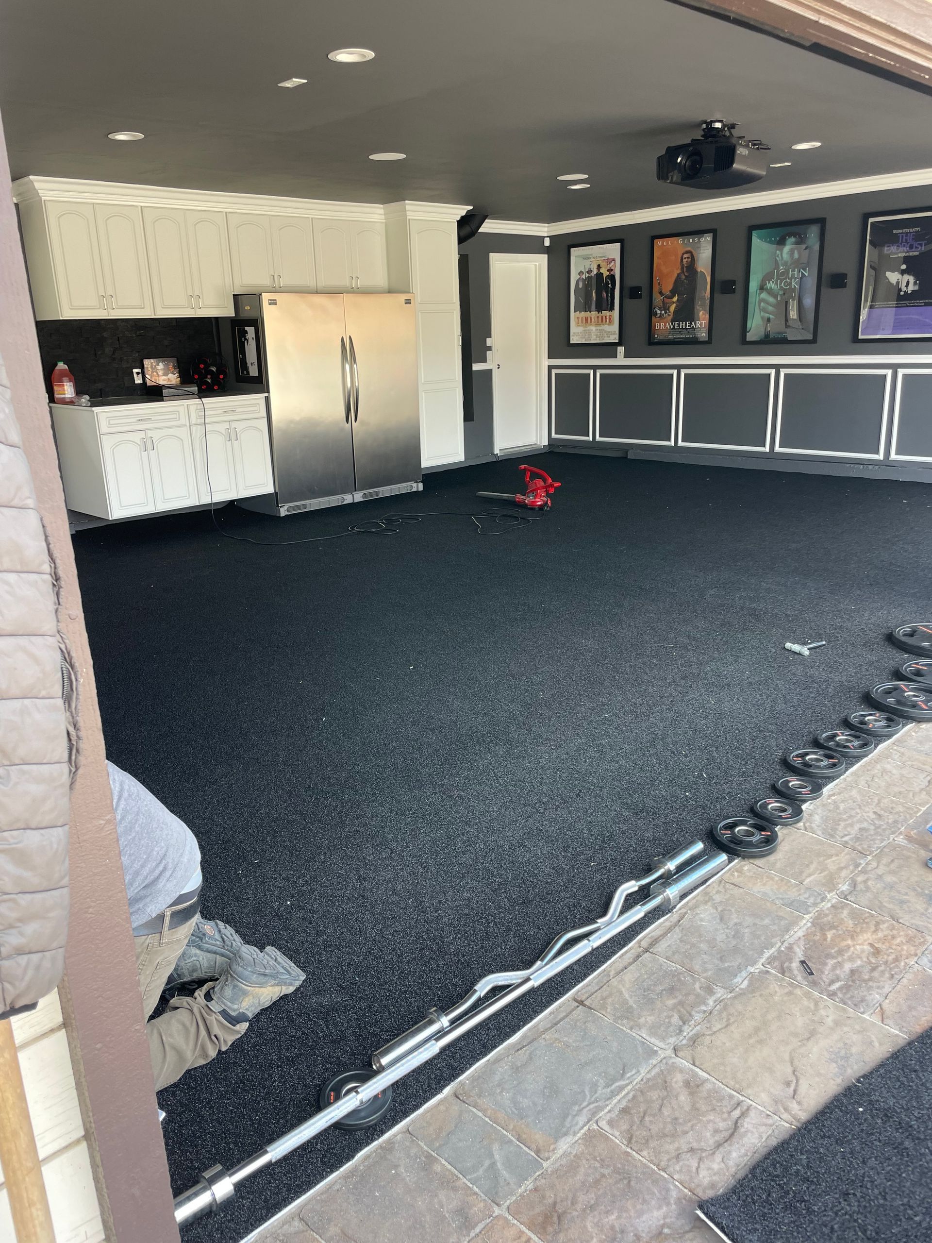 Garage with dark flooring, kitchen, and movie posters on the wall.
