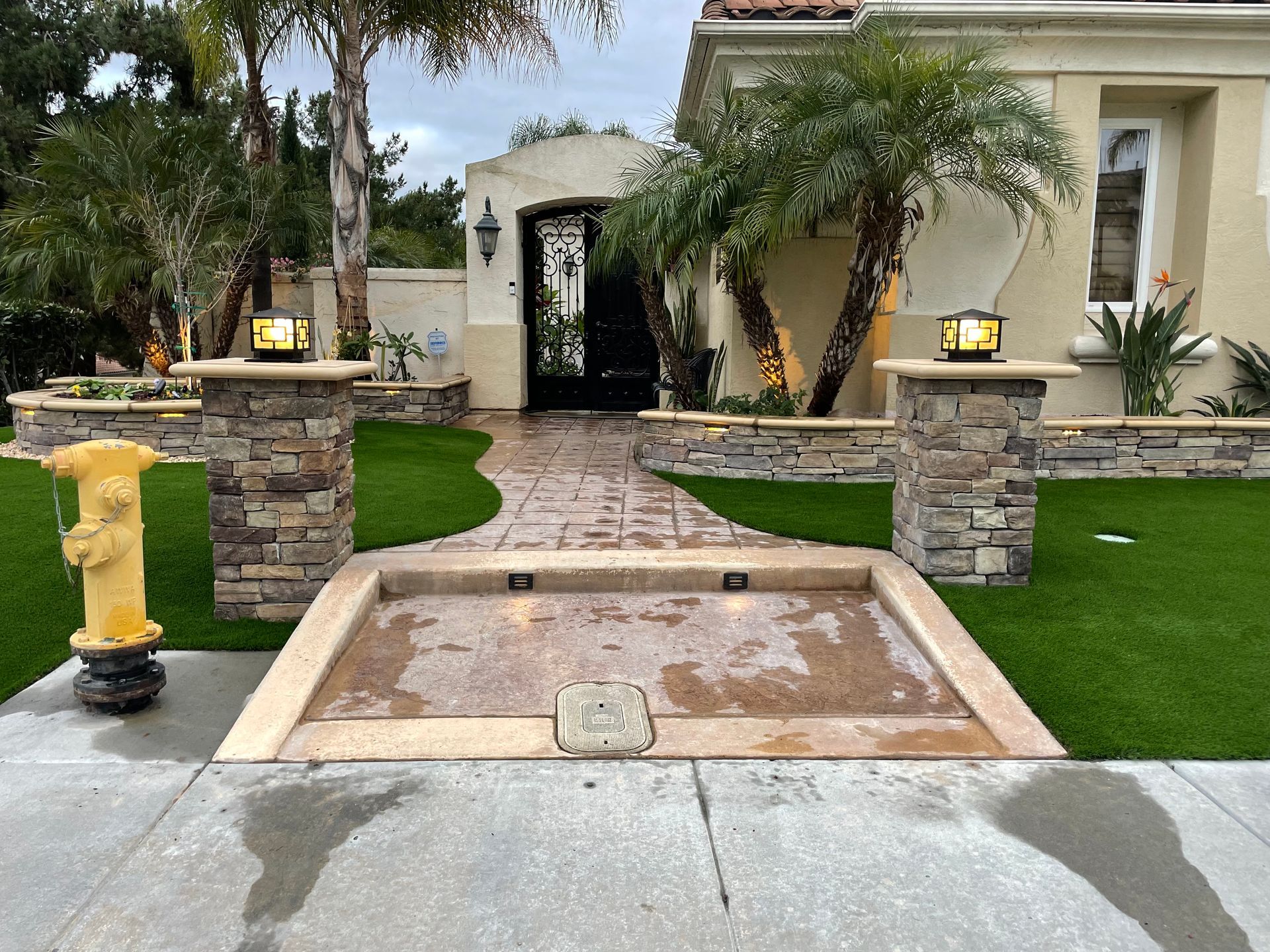 Exterior of a house with a stone pathway, landscaping, and a yellow fire hydrant.