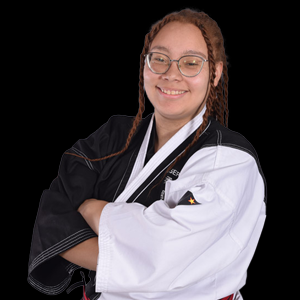 Person in karate uniform with arms crossed, smiling, black and white gi, glasses.