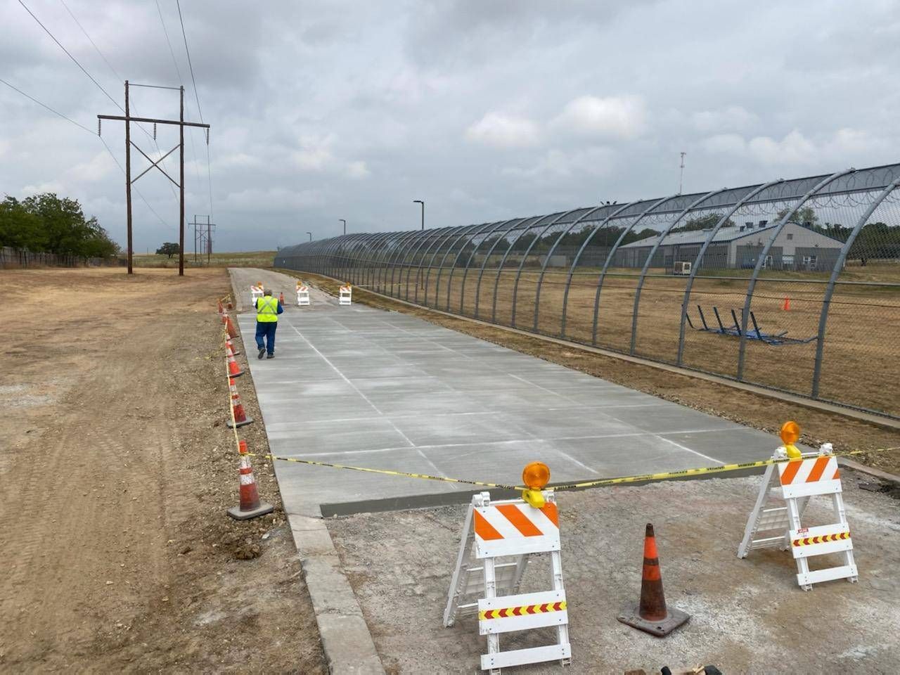 two construction workers are walking down a concrete road